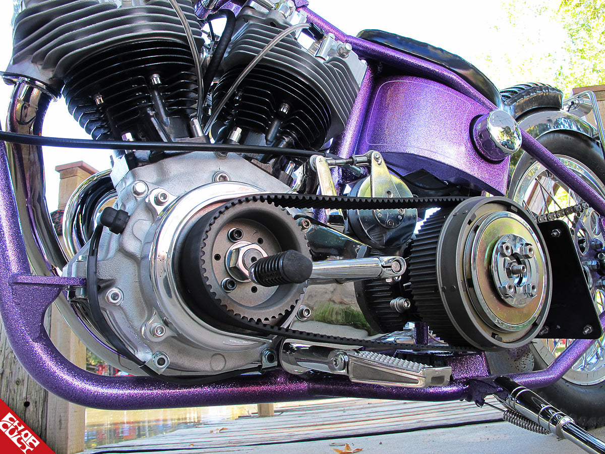 A close up of the bike's motor, belt, and foot pegs