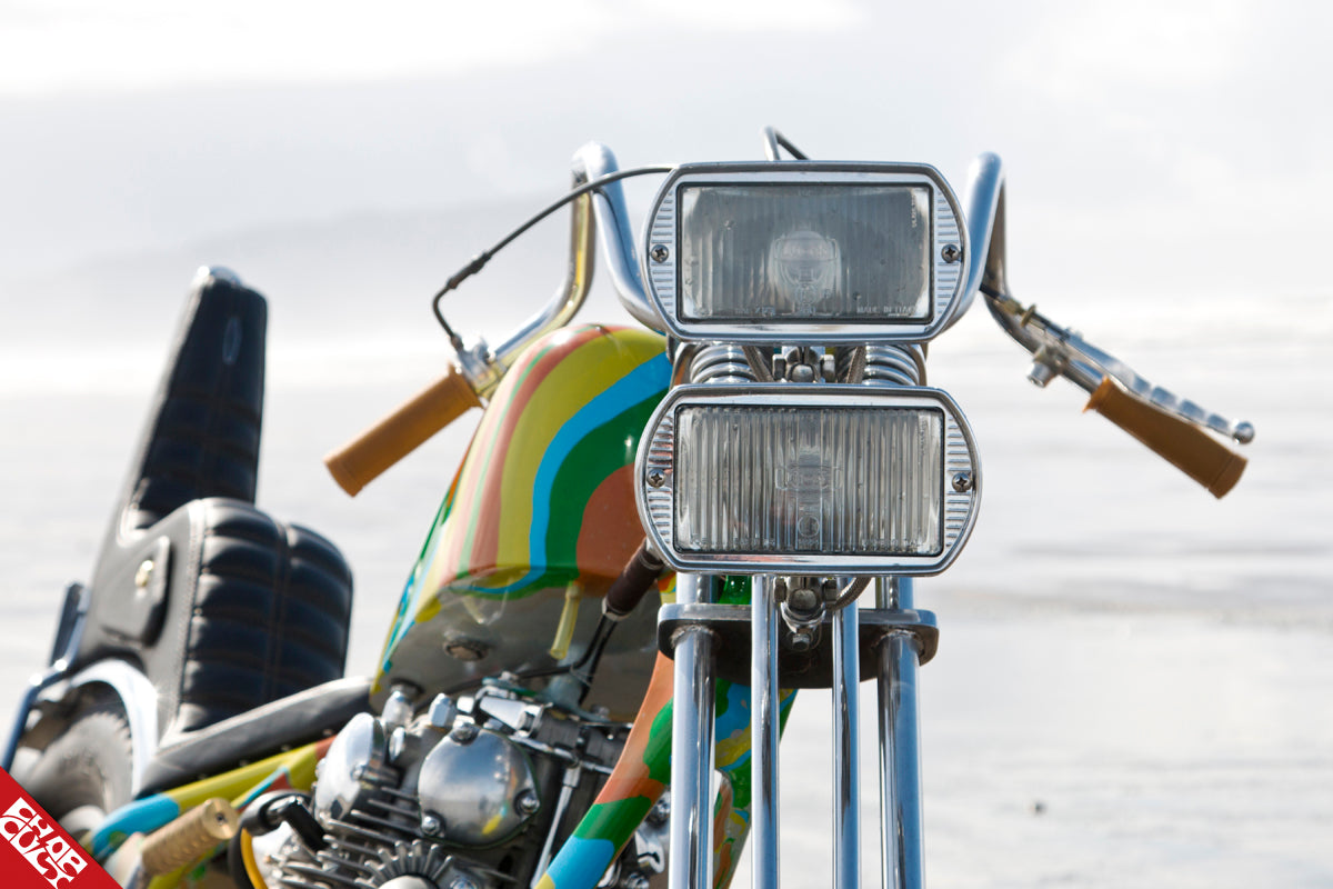 A close up of the bike's handle bars and square headlights